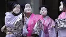 Seniman yang mengenakan topeng Otafuku atau Okame tradisional Jepang bersiap untuk berpartisipasi dalam Festival Konpira di kuil Kotohiragu di distrik bisnis Toranomon, Tokyo, Selasa (10/1/2023).  (AP Photo/Eugene Hoshiko)