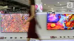 Model melintas di depan dua LG QNED Mini LED TV di toko elektronik SCBD, Jakarta, Sabtu (25/09/2021). PT LG Electronics Indonesia (LG) resmi mengumumkan TV premium, LG QNED Mini LED TV yang dikembangkan dua teknologi pada  LCD TV yaitu Quantum Dot NanoCell dan Mini LED. (Liputan6.com)