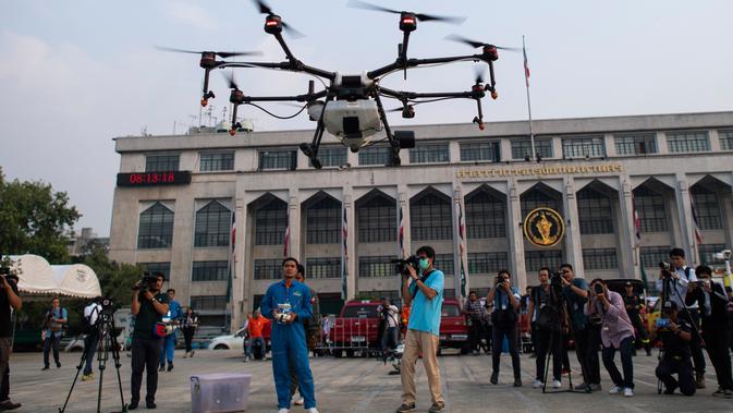 Petugas Administrasi Metropolitan Bangkok (BMA) melihat demonstrasi drone untuk menurunkan hujan buatan, Kamis (31/1). Thailand mengerahkan drone untuk menyemprotkan air dalam membantu memerangi polusi udara di Ibu Kota yang makin parah. (Jewel SAMAD/AFP)