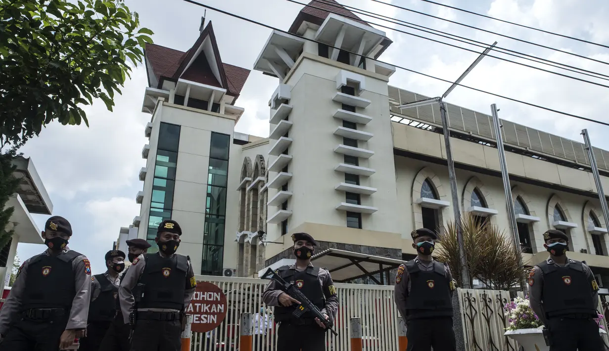 Anggota kepolisian berjaga saat proses penyisiran sebuah gereja di Surabaya menjelang Paskah setelah bom bunuh diri di katedral Makassar, Rabu (31/3/2021). Kegiatan tersebut merupakan upaya peningkatan pengamanan tempat ibadah, khususnya gereja di kota pahlawan. (Juni Kriswanto/AFP)