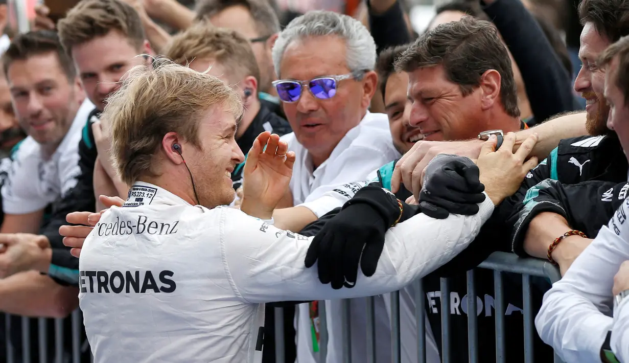 Nico Rosberg bersama tim seusai kemenangannya dalam seri ke-17 Formula One (F1) GP Jepang, Minggu (9/10). Kemenangan Rosberg juga membuat tim Mercedes merebut gelar juara dunia konstruktor musim ini. (REUTERS/Toru Hanai)