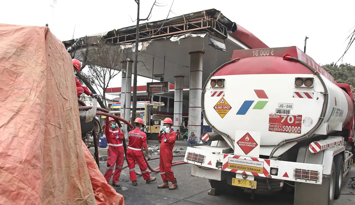 Petugas Pertamina menyedot sisa isi bahan bakar pada truk tangki yang terbakar di SPBU Jalan Kahfi 2, Jagakarsa, Jakarta, Sabtu (30/12). Tidak ada korban jiwa atas insiden itu karena SPBU tidak beroperasi saat kejadian. (Liputan6.com/Herman Zakharia)