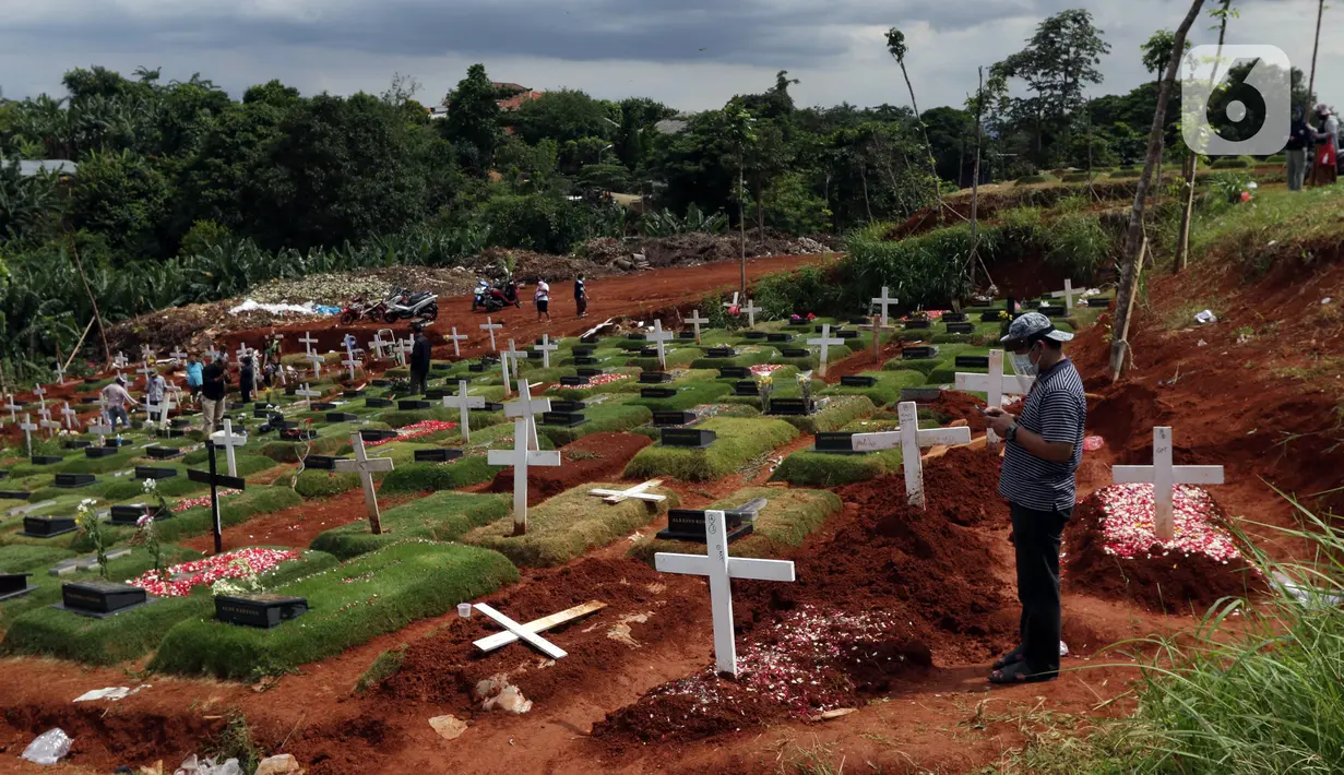 Warga berziarah di area pemakaman khusus dengan protokol COVID-19 di TPU Pondok Ranggon, Jakarta, Jumat (25/12/2020). Momen perayaan Natal 2020 dimanfaatkan sejumlah umat kristiani untuk berziarah mendoakan kerabat yang dimakamkan dengan protokol COVID-19. (Liputan6.com/Helmi Fithriansyah)