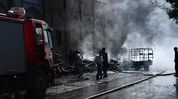 Petugas damkar memadamkan api yang berasal dari ledakan bom sepeda motor di luar sebuah masjid bersejarah di kota Herat, Afghanistan, Selasa (6/6). Para korban terkena ledakan saat berjalan ke masjid untuk salat selama bulan Ramadan. (HOSHANG HASHIMI/AFP)