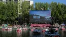 Orang-orang di atas kapal menghadiri Cinema on the Water, yang diselenggarakan Paris Plages selama pemutaran "Le Grand Bain" di Paris, Prancis pada 18 Juli 2020. Paris menghadirkan terobosan baru dengan bioskop terapung lengkap dengan perahu yang tetap menjaga jarak. (AP Photo/Rafael Yaghobzadeh)