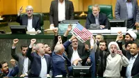 Detik-detik anggota parlemen Iran membakar dua lembar kertas bergambar bendera AS, Teheran, Iran, Rabu (9/5). Donald Trump menarik AS dari kesepakatan Nuklir Iran dan akan memberlakukan kembali sanksi terhadap Teheran. (AP Photo)