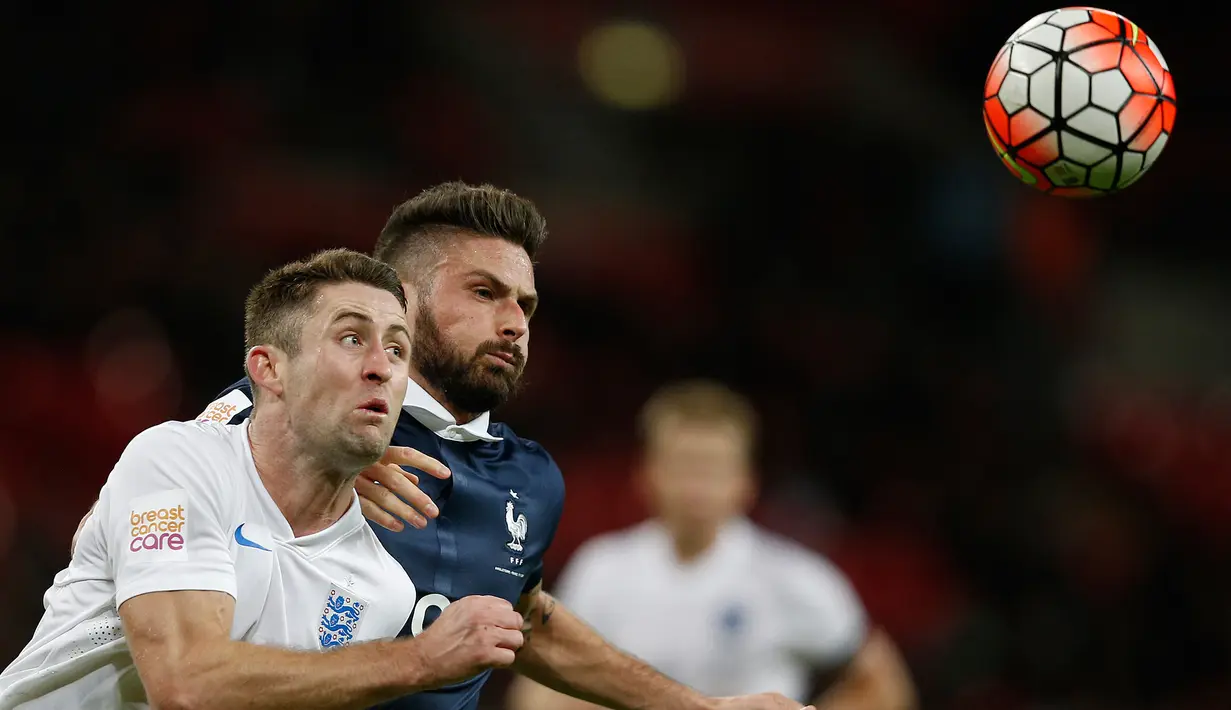 Penyerang Prancis, Olivier Giroud (kanan) berebut bola dengan bek Inggris, Gary Cahill pada laga persahabatan di Stadion Wembley, London, (18/11). Inggris menang atas Prancis dengan skor 2-0. (AFP PHOTO/ADRIAN DENNIS)