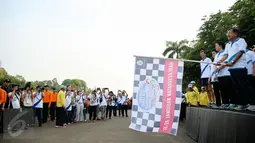 Wakil Presiden Jusuf Kalla memegang bendera tanda dimulainya jalan sehat  memperingati puncak Hari Kesehatan Nasional Ke-51 di Silang Monas, Jakarta, Minggu (6/12/2015). Acara tersebut dihadiri sebanyak 2000 peserta. (Liputan6.com/Faizal Fanani)