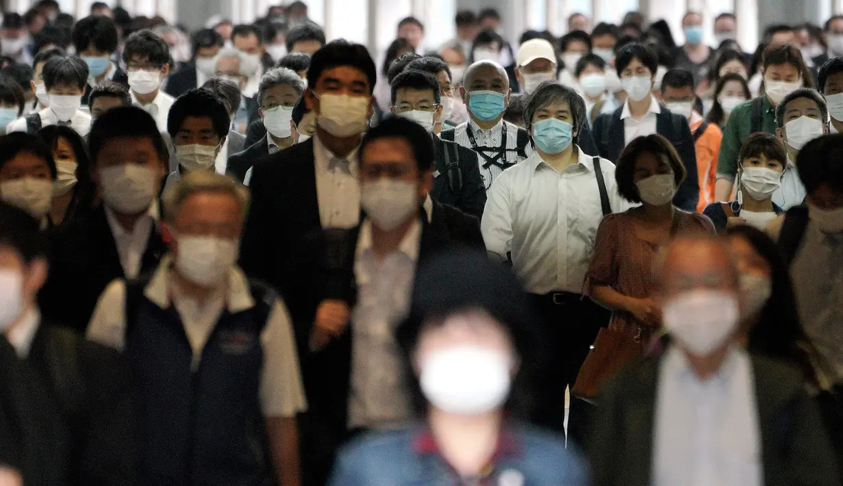 Para penumpang dengan menggunakan masker memenuhi sebuah lorong stasiun selama jam sibuk di Tokyo, Selasa (26/5/2020). Perdana Menteri Jepang Shinzo Abe mencabut keadaan darurat pandemi virus corona di Tokyo dan empat wilayah lainnya pada Senin (25/5). (AP Photo/Eugene Hoshiko)