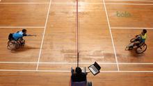 Atlet WC Bulutangkis, Wiwin berusaha menjangkau kok saat melawan  Supriadi (kanan) pada kategori Bulutangkis WH-2 di Istora Senayan, Jakarta (27/6/2018). Supriadi menang 21-11, 21-18. (Bola.com/Nick Hanoatubun)