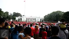 Antusias warga melihat anggota Paspampres melakukan prosesi pergantian jaga Istana Kepresiden di depan Istana Merdeka, Minggu (28/8). Ini merupakan pelaksanaan seremoni pergantian pasukan jaga istana untuk yang kedua kalinya (Liputan6.com/Faizal Fanani)