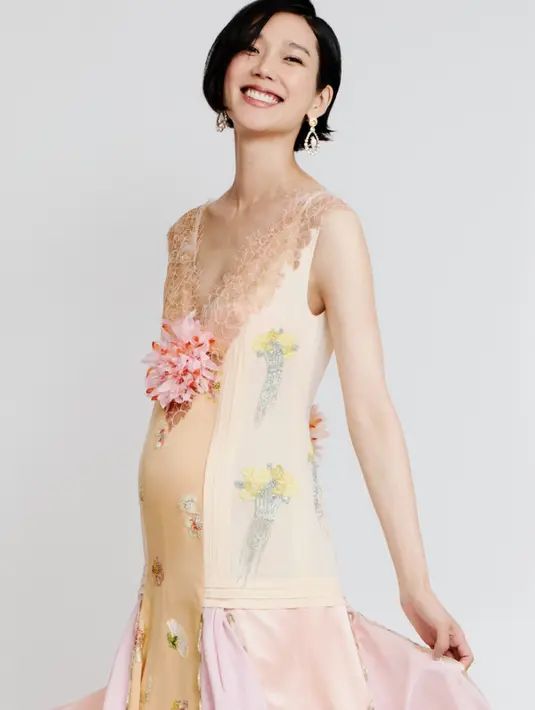 Tao Okamoto membawa sisi feminin artistik Chanel lewat gaun sleeveless bernuansa pastel lembut. Detail lace pada neckline dipadukan aksen floral embroidery dan aplikasi bunga tiga dimensi membuat tampilannya terasa whimsical sekaligus couture. [Dok/Chanel].