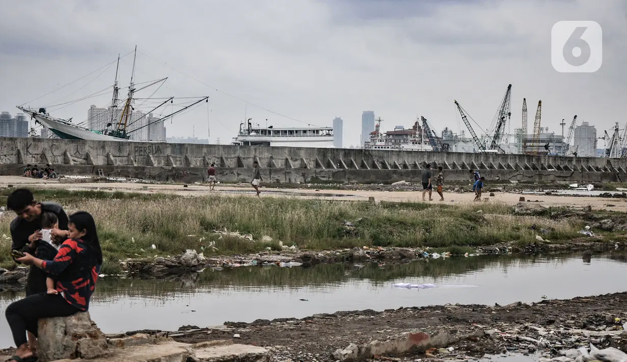 Warga beraktivitas dekat tanggul laut Muara Baru, Jakarta, Rabu (19/1/2022). Badan Pusat Statistik (BPS) mencatat angka kemiskinan di Indonesia turun menjadi 26,5 juta orang per September 2021 dari sebelumnya mencapai 27,54 juta orang pada Maret 2021. (merdeka.com/Iqbal S Nugroho)