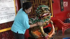 Seorang ibu membersihkan patung di Vihara Amurva Bhumi, Jakarta, Kamis (8/2). Berbagai persiapan dilakukan untuk menyambut perayaan Tahun Baru Imlek 2569. (Liputan6.com/Arya Manggala)