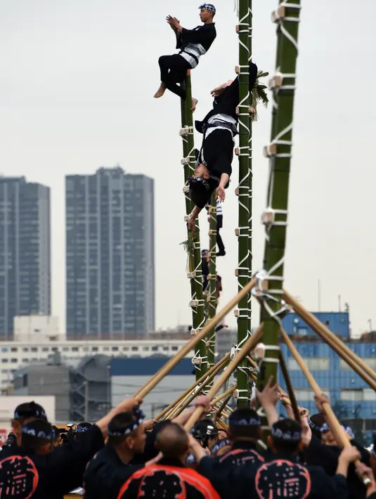 Para pemadam kebakaran berpakaian tradisonal memperlihatkan atraksi berbahaya berdiri di atas bambu saat perayaan Tahun Baru di Tokyo, Jepang, Jumat (6/1). Mereka memperlihatkan berbagai aksi-aksi mendebarkan di atas bambu. (Toshifumi KITAMURA/AFP)