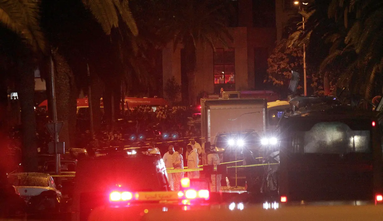 Petugas forensik berkumpul di lokasi ledakan sebuah bus yang mengangkut pengawal Presiden Tunisia di Tunis, Selasa (24/11). Insiden yang diduga akibat serangan bom bunuh diri itu menewaskan 12 orang dan melukai 16 lainnya. (AFP PHOTO/ KHALIL MOHAMED)