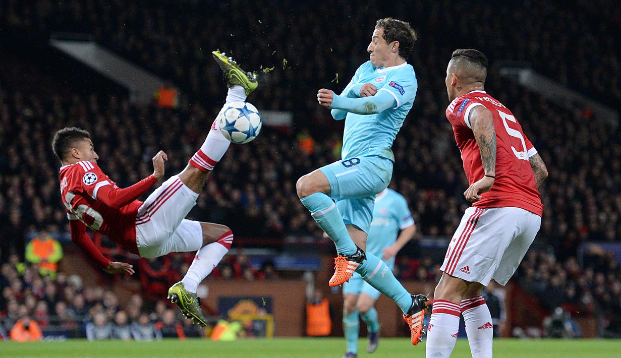 Pemain Manchester United, Jesse Lingard (kiri) berusaha melakukan tendangan salto ke gawang PSV Eindhoven dalam laga Grup B Liga Champions di Stadion Old Trafford, Manchester, (25/11/2015). (AFP Photo/Oli Scarff)