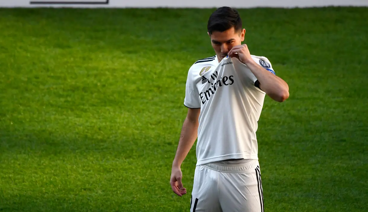 Brahim Diaz mencium jersey klub barunya Real Madrid saat diperkenalkan ke publik di stadion Santiago Bernabeu  (7/1). Diaz bakal memakai nomor punggung 21 yang sebelumnya digunakan oleh pelatih Real Madrid, Santiago Solari. (AFP Photo/Gabriel Bouys)