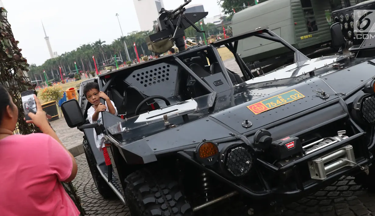 Seorang anak berfoto di atas kendaraan taktis TNI pada pameran Alat Utama Sistem Persenjataan TNI di Kawasan Monas, Jakarta, Kamis (27/9). Pameran ini bagian perayaan HUT TNI ke-73. (Liputan6.com/Helmi Fithriansyah)