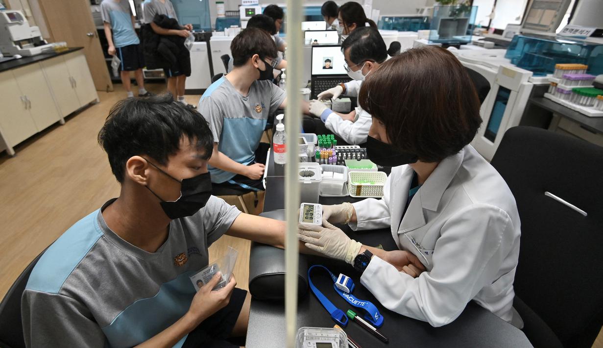 Pemuda Korea Selatan menjalani tes darah saat pemeriksaan medis untuk wajib militer di Administrasi Tenaga Kerja Militer Regional Seoul, Seoul, Korea Selatan, Rabu (1/2/2023). Masa wajib militer untuk tiap orang berbeda-beda karena sejumlah faktor, mulai dari cabang militer tempat mereka berada, tugas aktif, dan non-aktif. (Jung Yeon-je/AFP)