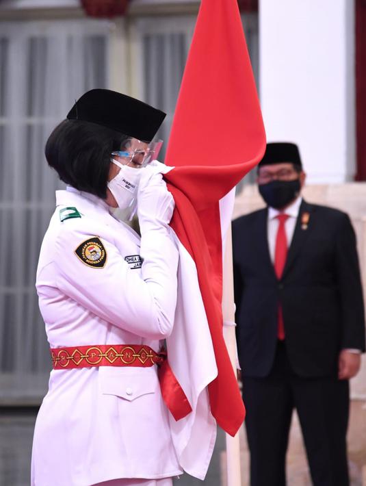 Anggota Pasukan Pengibar Bendera Pusaka (Paskibraka) mencium bendera Merah Putih saat upacara pengukuhan di Istana Negara, Kamis (13/8/2020). Presiden Joko Widodo mengukuhkan 8 anggota Paskibraka yang akan bertugas pada upacara HUT ke-75 Kemerdekaan RI. (Foto: Lukas - Biro Pers Sekretariat Presiden)
