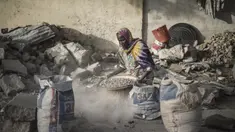 Habiba, penghancur kerikil berusia 50-60 tahun, mengayak dengan saringan improvisasi untuk memisahkan kerikil dari pasir di dekat Cite International des Affaires, N'Djamena, Chad, 12 April 2021. Dalam debu dan panas, wanita Chad menghancurkan kerikil untuk memenuhi kebutuhan. (MARCO LONGARI/AFP)