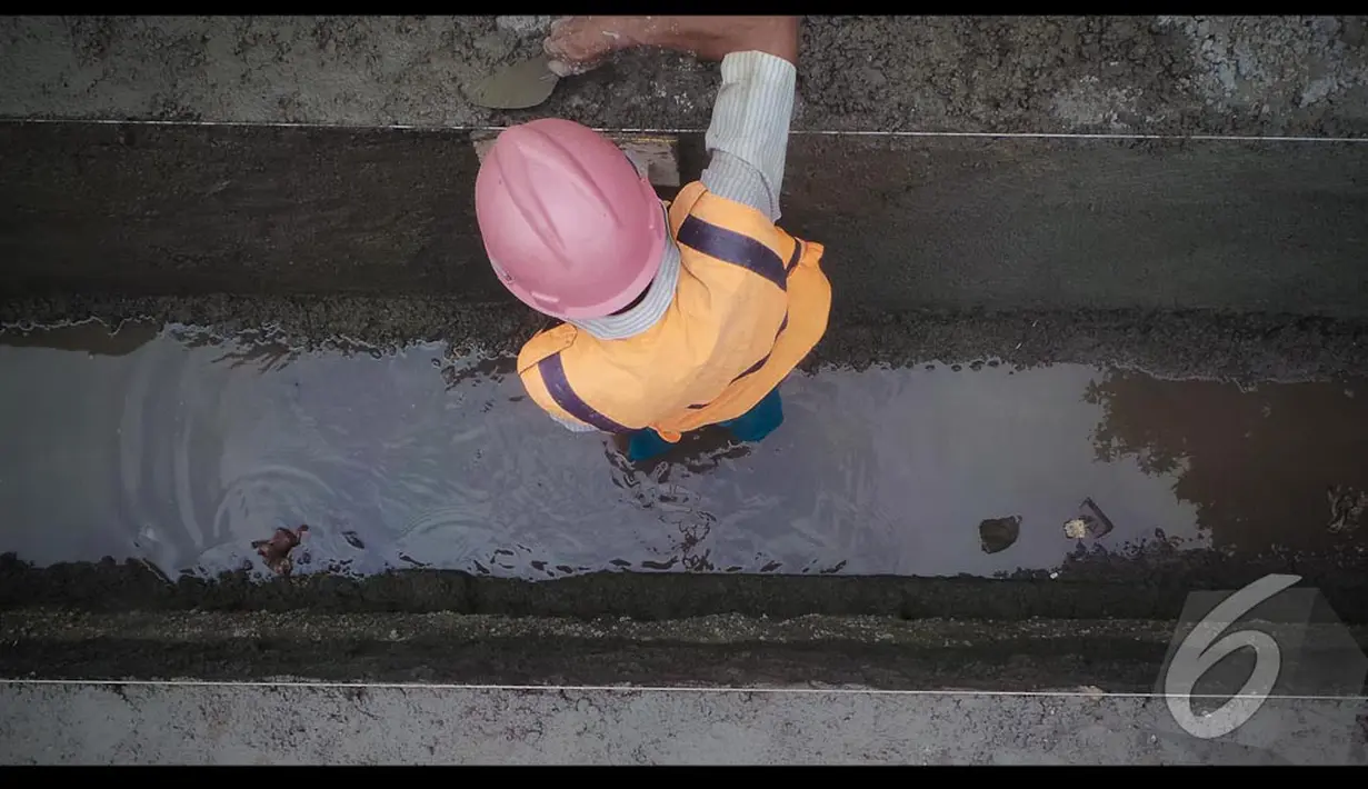 Pekerja sedang menyelesaikan pembuatan saluran sdpu tata air di jalan Agus Salim, Jakarta, Senin (11/8/2014) (Liputan6.com/Faizal Fanani)