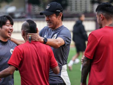Pelatih Kepala Timnas Indonesia, Shin Tae-yong (kanan kedua) bercanda dengan pemainnya, Riko Simanjuntak dan penerjemahnya, Jeong Seok-seo saat latihan perdana Timnas Indonesia yang berlangsung di Stadion PTIK, Jakarta, Senin (20/03/2023) sore WIB. Skuad Garuda rencananya akan melakoni laga FIFA Match Day melawan Burundi pada 25 dan 28 Maret 2023 di Stadion Patriot Candrabhaga, Bekasi. (Bola.com/Bagaskara Lazuardi)