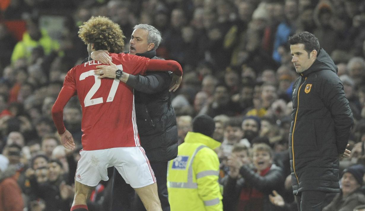 Pelatih Manchester United, Jose Mourinho memeluk anak asuhnya Marouane Fellaini usai gol kedua saat melawan Hull City pada laga semifinal leg pertama PIala Liga Inggris di Old Trafford stadium, Manchester, (10/1/2017). MU menang 2-0. (AP/Rui Vieira)