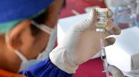 Seorang petugas kesehatan menyiapkan dosis vaksin virus corona COVID-19 AstraZeneca di Denpasar, Bali, Sabtu (26/6/2021). Ratusan warga terlihat antusias mengikuti vaksinasi massal tersebut. (SONY TUMBELAKA/AFP)