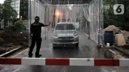 Petugas mengarahkan mobil saat memasuki bilik disinfektan di Perumahan Tamansari Persada Raya, Jatibening, Bekasi, Jawa Barat, Selasa (31/3/2020). Bilik disinfektan dipasang untuk mencegah penyebaran virus corona COVID-19 di area kompleks. (Iqbal S. Nugroho)