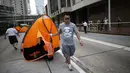 Salah satu anggota kelompok anti-demokrasi menyeret tenda massa pro-demokrasi dari lokasi utama berlangsungnya aksi demonstasi massa pro-demokrasi di Admiralty, Hong Kong, (13/10/2014). (REUTERS/Carlos Barria)