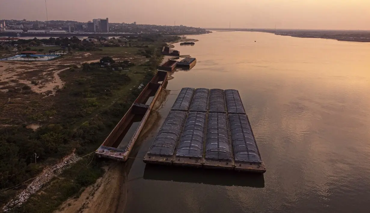Tongkang menunggu untuk diangkut di tengah kekeringan berkelanjutan yang mempengaruhi ketinggian air sungai Paraguay di pantai tepi San Miguel, Paraguay, Senin (20/9/2021).  (AP Photo/Jorge Saenz)