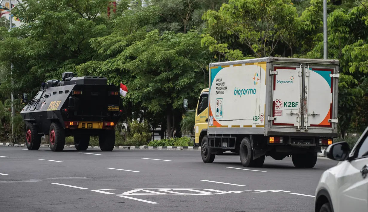Sebuah truk (kanan) yang membawa vaksin COVID-19 produksi Sinovac dengan pengawalan polisi tiba di Surabaya, Senin (4/1/2021).  Pemerintah mulai mendistribusikan 3 juta dosis vaksin Covid-19 asal perusahaan China, Sinovac, ke 34 provinsi Indonesia. (Photo by Juni Kriswanto / AFP)