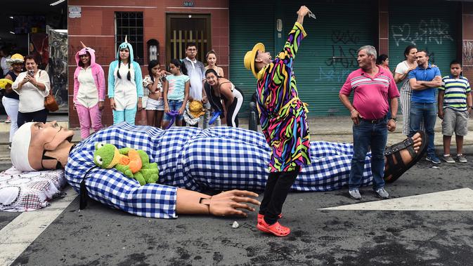 Orang-orang mengambil bagian dalam pawai untuk merayakan Hari Kemalasan Sedunia di Itagui, dekat Medellin, Minggu (19/8). Warga Kolombia dalam perayaan ini akan mengankut kasur mereka ataupun tempat tidur gantungnya di jalan-jalan. (AFP/JOAQUIN SARMIENTO)