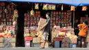 Warga berjalan di depan kios penjual kue kering musiman di kawasan Ciracas, Jakarta, Minggu (12/7/2015). Sejak beberapa hari terakhir, transaksi pedagang musiman kue kering mengalami peningkatan menjelang hari raya Idul Fitri. (Liputan6.com/Helmi Afandi)