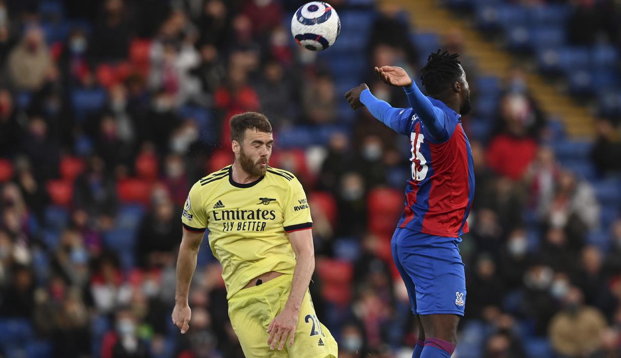 Bek Crystal Palace, Jeffrey Schlupp melompat saat berebut bola dengan bek Arsenal, Calum Chambers pada pekan ke-37 Liga Inggris, Kamis (20/5/2021) dini hari WIB. The Gunners -julukan Arsenal- menang dengan skor 3-1 di markas Crystal Palace. (Facundo Arrizabalaga/Pool Photo via AP)