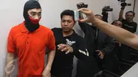 Tersangka pemukulan jurnalis TV, Kashira Uozumi, dibawa petugas saat jumpa pers di Mapolres Metro Jakarta Selatan, Kamis (13/4). Kashira Uozumi terbukti meludahi dan memukul jurnalis NET TV Haritz Ardiansyah. (Liputan6.com/Immanuel Antonius)