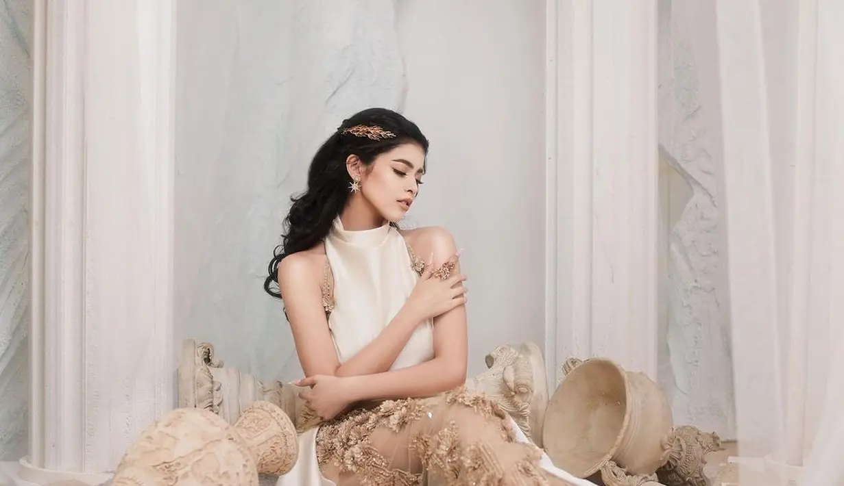 Rambutnya ditata bergaya half updo, dipermanis dengan aksesori rambut berbentuk dedaunan warna emas. [@jharnabhagwani]