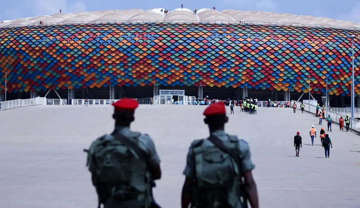 Tentara Kamerun berpatroli di pintu masuk Stadion Olembe yang terletak di Yaounde, pada 7 Januari 2022. Stadion yang berkapasitas 60.000 penonton tersebut rencananya akan digunakan untuk venue pembukaan Piala Africa 2021. (AFP/Kenzo Tribouillard).