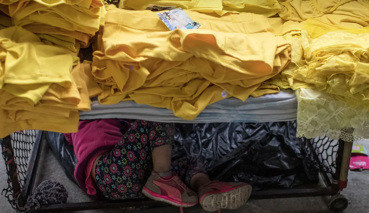 Sebuah keluarga memilih celana dalam berwarna kuning untuk dipakai pada perayaan tahun baru di Medellin, Kolombia, Jumat (29/12). Selain di Kolombia, tradisi unik ini sudah lama dianut oleh warga beberapa negara di Amerika. (Joaquin SARMIENTO / AFP)