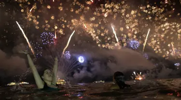 Seorang wanita menyaksikan pesta kembang api menyambut Tahun Baru 2019 di Pantai Copacabana, Rio de Janeiro, Brasil, Selasa (1/1). (AP Photo/Leo Correa)