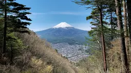 Gunung Fuji terlihat dari pinggiran kota Fujiyoshida, prefektur Yamanashi, Jepang, pada Kamis (22/4/021). Pada tahun 2014, Gunung Fuji terpilih sebagai UNESCO World Culture Heritage Site (Situs Warisan Budaya Dunia). (Behrouz MEHRI / AFP)