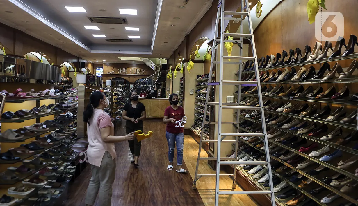 Karyawan bersiap memasang ornamen untuk mempercantik toko jelang bulan suci Ramadhan di Pasar Baru, Jakarta, Rabu (9/3/2022). Selain untuk mempercantik toko, pemasangan ornamen juga untuk menarik perhatian pengunjung atau warga yang hendak berbelanja ke toko tersebut. (Liputan6.com/Johan Tallo)