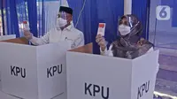 Calon Wali Kota Depok nomor urut 2 Mohammad Idris ditemani istrinya Elly Farida menggunakan hak pilih pada Pilkada 2020 di TPS 14 Jatimulya, Depok, Rabu (9/12/2020). Pilkada Depok 2020 diikuti oleh Pradi Supratna-Afifah Alia serta Mohammad Idris dan Imam Budi Hartono. (Liputan6.com/Herman Zakharia)