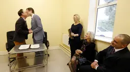 Richard Dowlin dan Cormac Gollogly berciuman saat proses pernikahan mereka di kantor the South Clonmel Community Care Centre di Irlandia, (17/11/2015). Dowlin dan Gollogly adalah pasangan gay pertama yang menikah di Irlandia. (REUTERS/Cathal McNaughton)