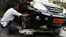 Petugas Dishub memasang tali derek saat razia parkir liar di kawasan Tanah Abang, Jakarta, Senin (14/11). Meski sudah ditertibkan, pengendara masih tak menghiraukan peraturan tersebut yang mengakibatkan kemacetan. (Liputan6.com/Gempur M Surya)