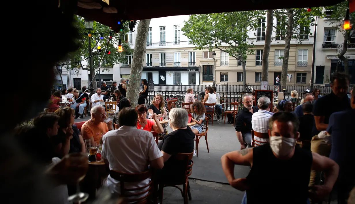 Orang-orang duduk di teras kafe di Paris pada Selasa (2/6/2020). Balai Kota Paris mengizinkan pembukaan area tempat duduk area luar (outdoor) kafe, tetapi di dalam ruangan akan tetap tertutup bagi pelanggan sampai setidaknya 22 Juni mendatang. (AP Photo/Thibault Camus)