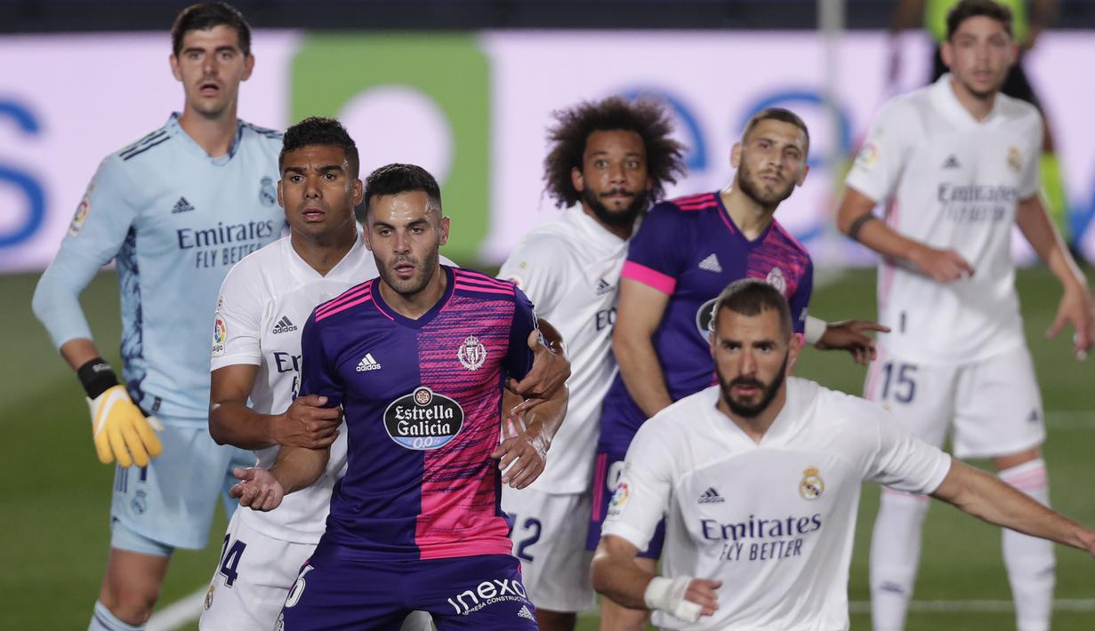 Penyerang Real Madrid, Karim Benzema, berebut bola dengan pemain Real Valladolid pada laga lanjutan Liga Spanyol di Estadio Alfredo Di Stefano, Kamis (1/10/2020) dini hari WIB. Real Madrid menang 1-0 atas Valladolid. (AP Photo/Manu Fernandez)