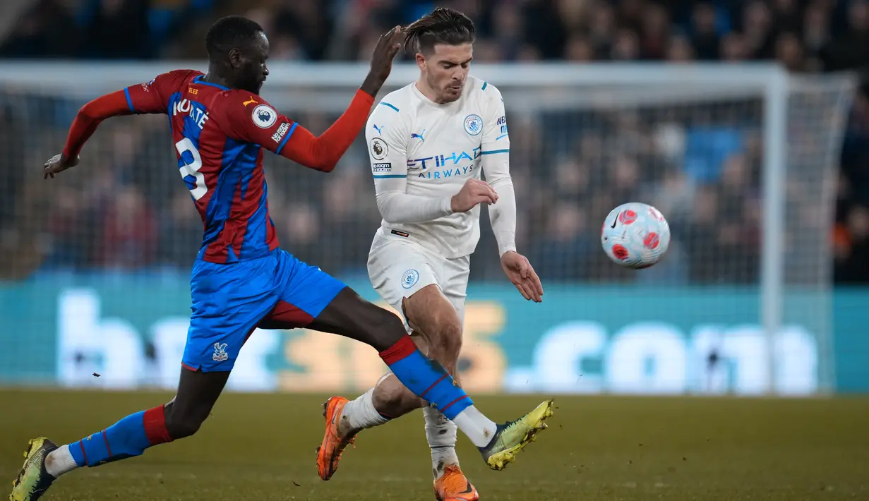 Gelandang Manchester City, Jack Grealish berusaha melewati pemain Crystal Palace, Cheikhou Kouyate dalam pertandingan lanjutan Liga Inggris di Selhurst Park, London, Selasa (15/3/2022). Manchester City bermain imbang atas Crystal Palace 0-0. (AP Photo/Matt Dunham)